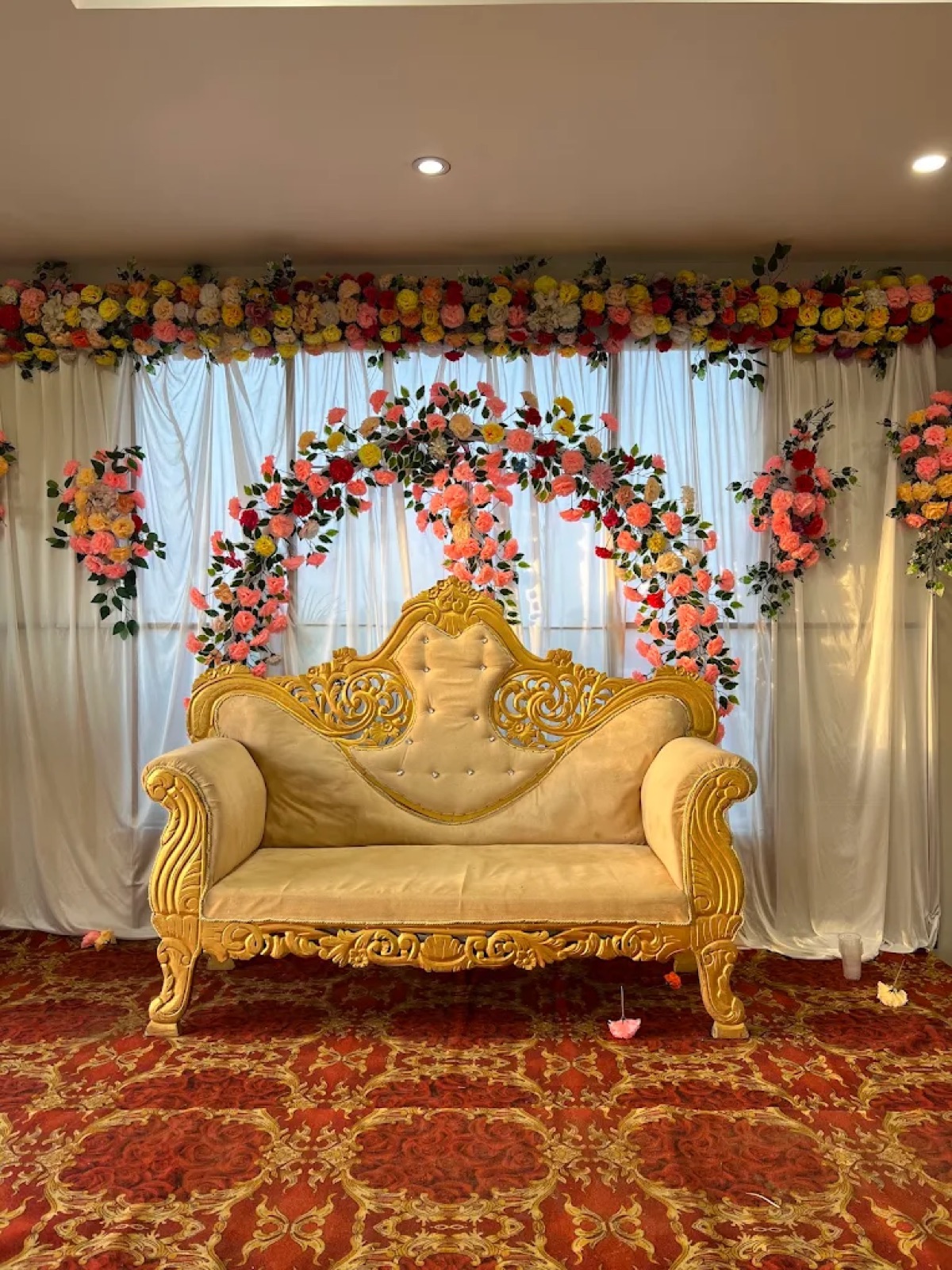 Golden wedding stage sofa with floral backdrop at Shri Nath Palace, Deoghar